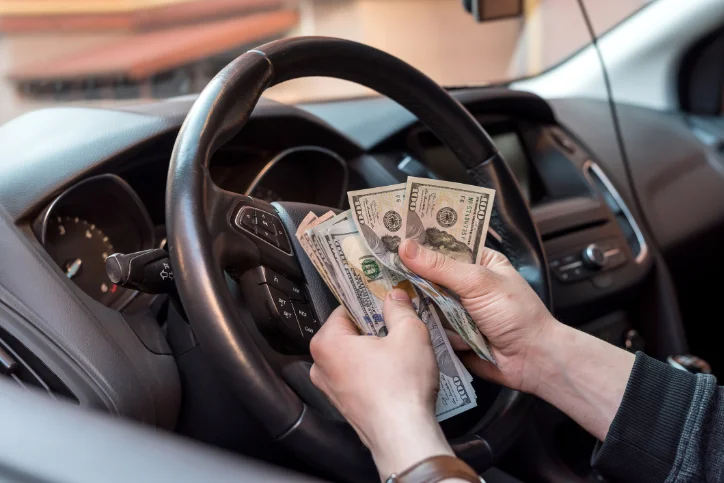 Driver sitting in car counting money